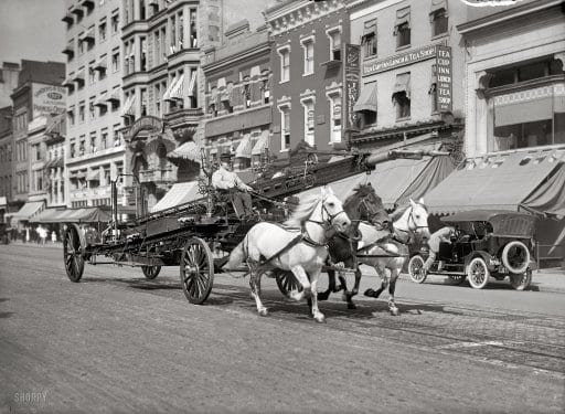 Washington, D.C., circa 1914. "Three-horse team pulling water tower." A fire truck racing past the Tea Cup Inn on F Street. Harris & Ewing