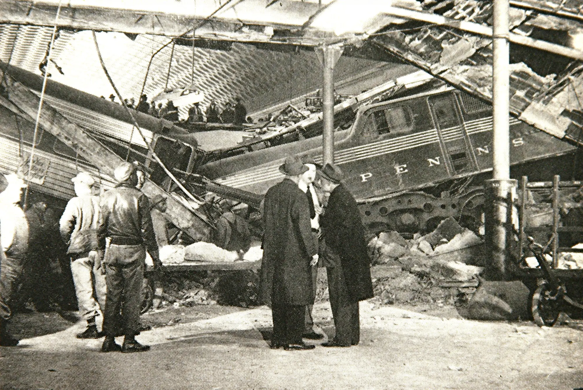 Officials inspect the wrecked train that had crashed through the floor of the concourse. (Photo courtesy of Trains Magazine, August 1953)