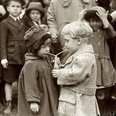 Two kids sharing one soda
