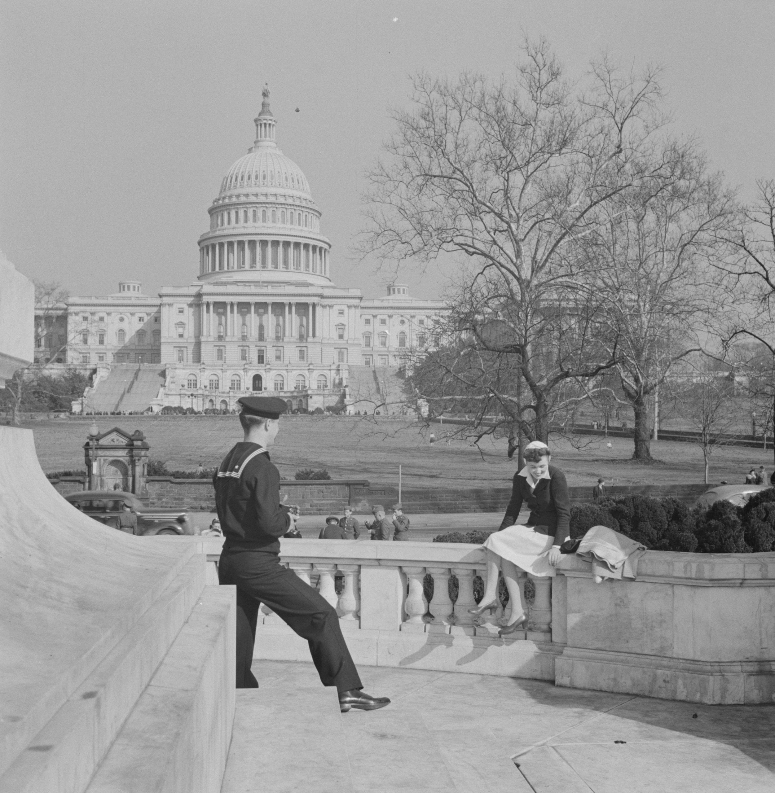 Washington, D.C. Sailor taking a picture of his girlfriend at a monument in front of the Capitol on a Sunday afternoon  