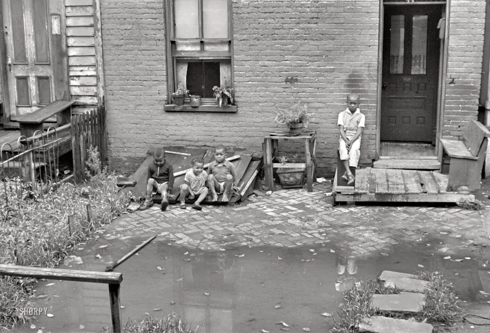 September 1935. A closeup of the Washington, D.C., row house seen here over the weekend. "Front of old brick structure in section near Union Station. Land is low here and water collects in front and backyard after a rain and remains for many days. Entrances to privies are usually under water. Interior of homes similar in shabbiness to exterior." 35mm nitrate negative by Carl Mydans for the Resettlement Administration.