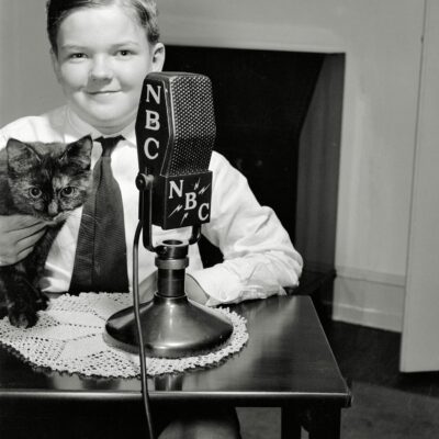 Washington, D.C., circa 1938. "Patrick Brennan, son of the Minister of Ireland, and Mrs. Brennan." Or something like that. One of a series of photographs depicting children of various diplomats speaking from their homes to a radio audience. Harris & Ewing Collection glass negative.