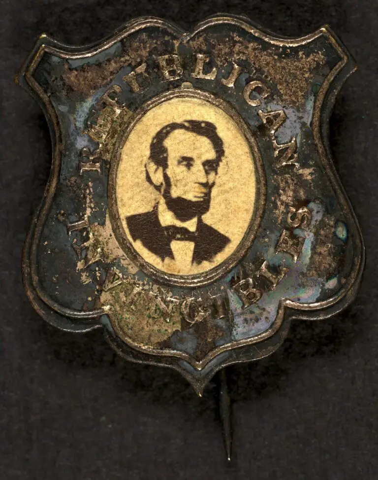 Political campaign button for 1864 presidential election showing bust portrait of Abraham Lincoln, facing right (possibly Wenderoth & Taylor photo); metal shield with oval window and with pin fastener attached.