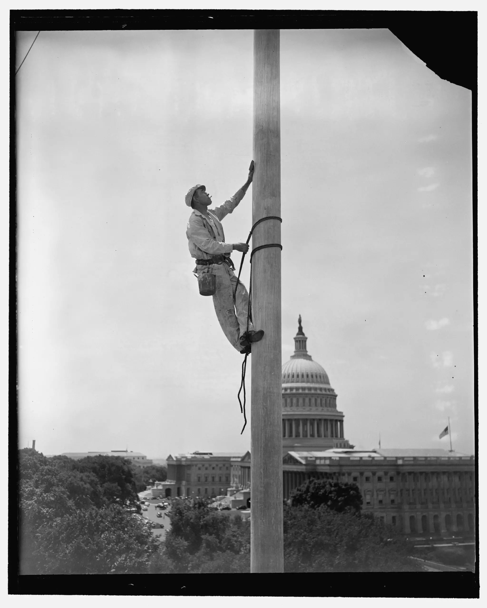 Washington, D.C., July 11, 1939. There comes a time each year when things around Capitol Hill need a bit of fresh paint, flagpoles no exception. Here is the flagpole over the Senate Office Building getting its new paint job, curiously enough, from a steeple-jack named Tarzan--Jack Tarzan