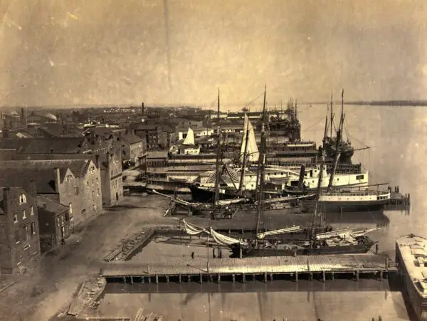 Photograph shows cargo ships at the wharf in Alexandria, Virginia from Pioneer Mill, which was six stories high.