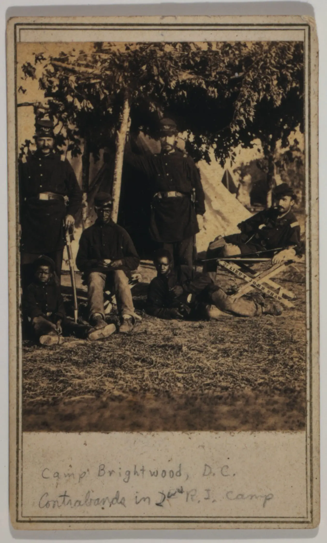 Capt. B.S. Brown (left); Lt. John P. Shaw, Co. F 2nd Regt. Rhode Island Volunteer Infantry (center); and Lt. Fry (right) with African American men and boy.