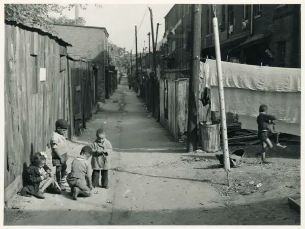 Children playing in the Defrees Alley, NE Washington, D.C.; Near Capitol Building; One basement room rents for $9.00 a month, two rooms upstairs for $ 16.00, one bath and cold water in the hall for entire building.. Wolcott, Marion Post -- Photographer