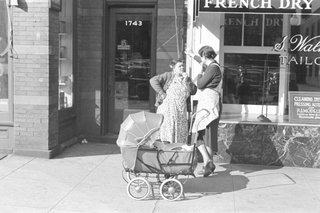 woman and carriage in front of store