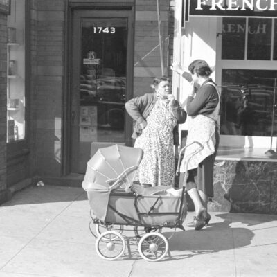 woman and carriage in front of store