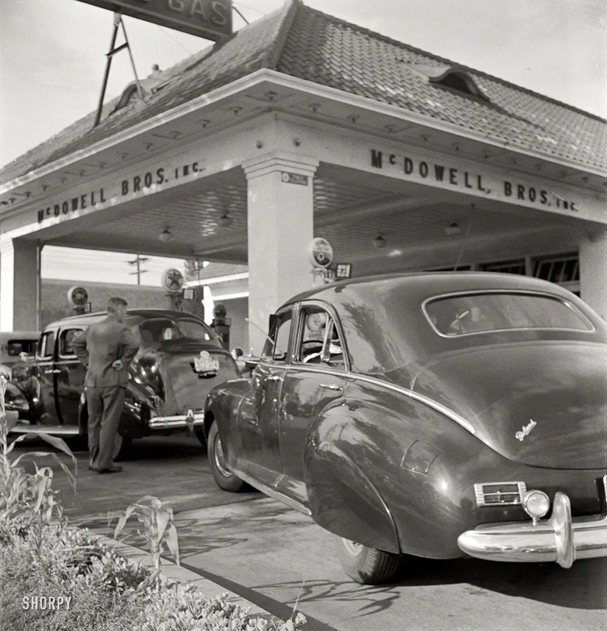 Washington, D.C. "At 7 a.m. on June 21, 1942, the day before stricter gas rationing was enforced, cars were pouring into this gas station on upper Wisconsin Avenue." If they still made cars that looked like this Packard, we'd run right out and buy one. Photo by Marjory Collins for the Office of War Information.