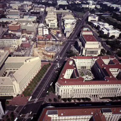 Aerial view of Washington, D.C., offering a good view of the "triangle" in the Federal Triangle row of federal office buildings.  Image taken during the 1980s.  Note the Navy Memorial construction