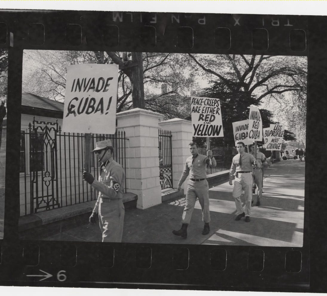 Demonstrators from a broad political spectrum picket outside the White House during the height of the Cold War confrontation between the United States and the Soviet Union over the placement of missile silos in Cuba. The Cuban missile crisis demonstration attracted elements on the fringe of American society as evidenced by the last panel frame showing members of an American neo-Nazi group protesting President John F. Kennedy’s “soft” stance on Cuba.