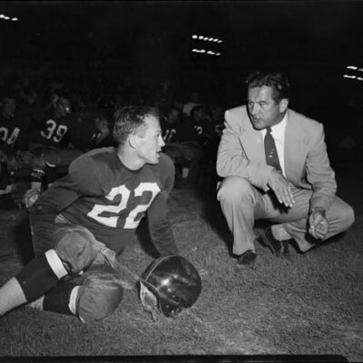 Charlie "Choo Choo" Justice on sidelines with Washington Redskins head coach Joe Kuharich during game versus the Green Bay Packers at Riddick Stadium, Raleigh, N.C., September 11, 1954