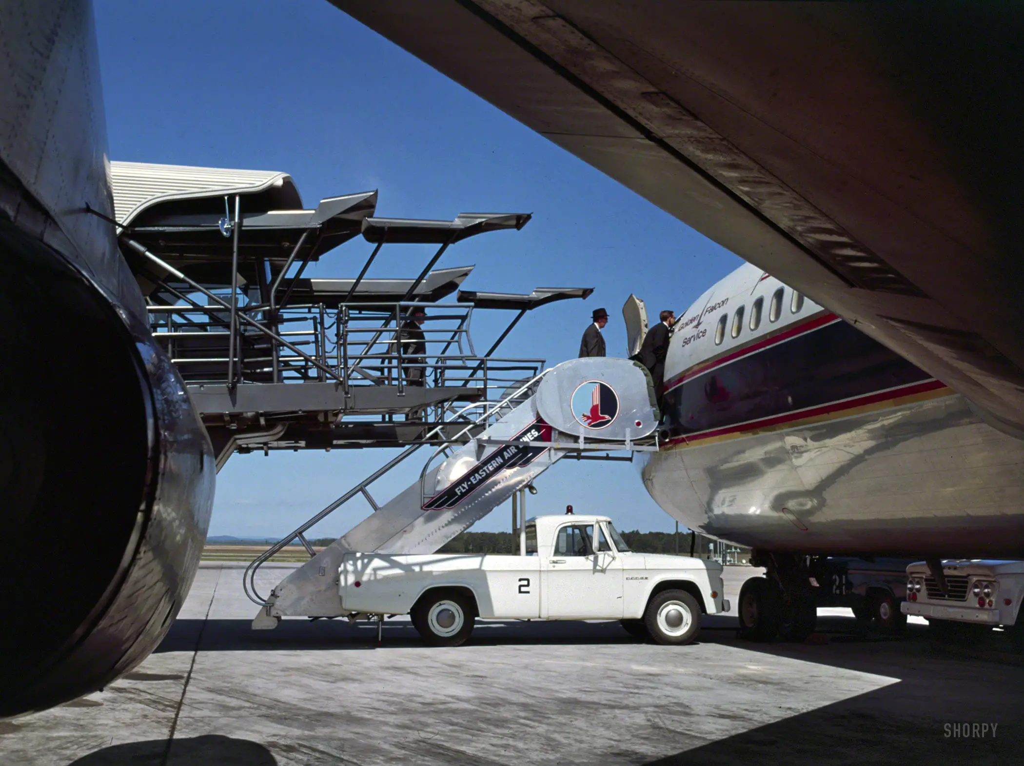 "Dulles International Airport, Chantilly, Va., 1958-63. Eero Saarinen, architect. Mobile lounges." A sort of giant rolling jetway (mostly out of frame at left) that carried passengers at Dulles from terminal to plane. The stair truck supported the gangway. 120mm color transparency by Balthazar Korab.
