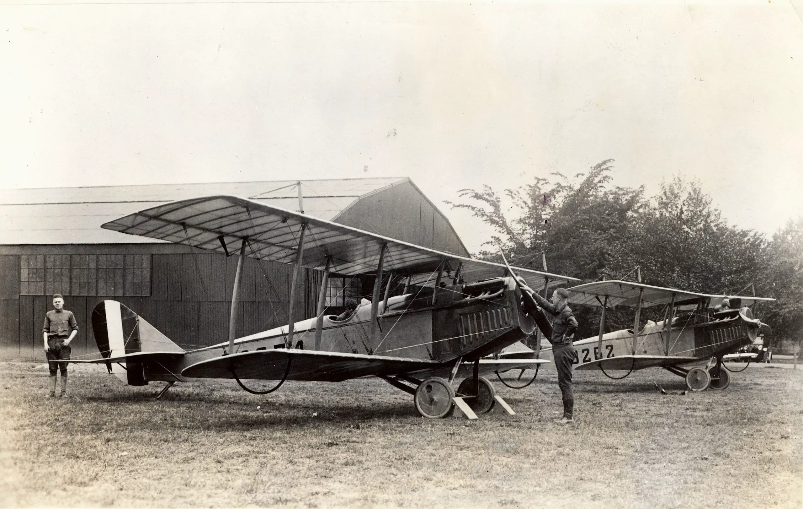 Two Curtiss JN-4H "Jenny" airmail planes parked at the temporary airmail field at Washington, DC’s Polo Field, a small strip of grassy land between the Tidal Basin and Potomac River.