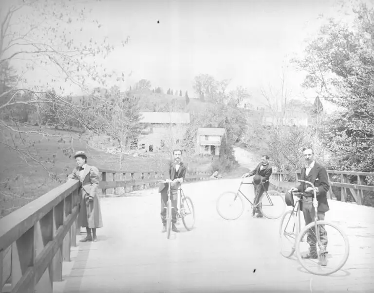 Three men with bicycles on bridge near Pierce Mill, Washington, D.C.