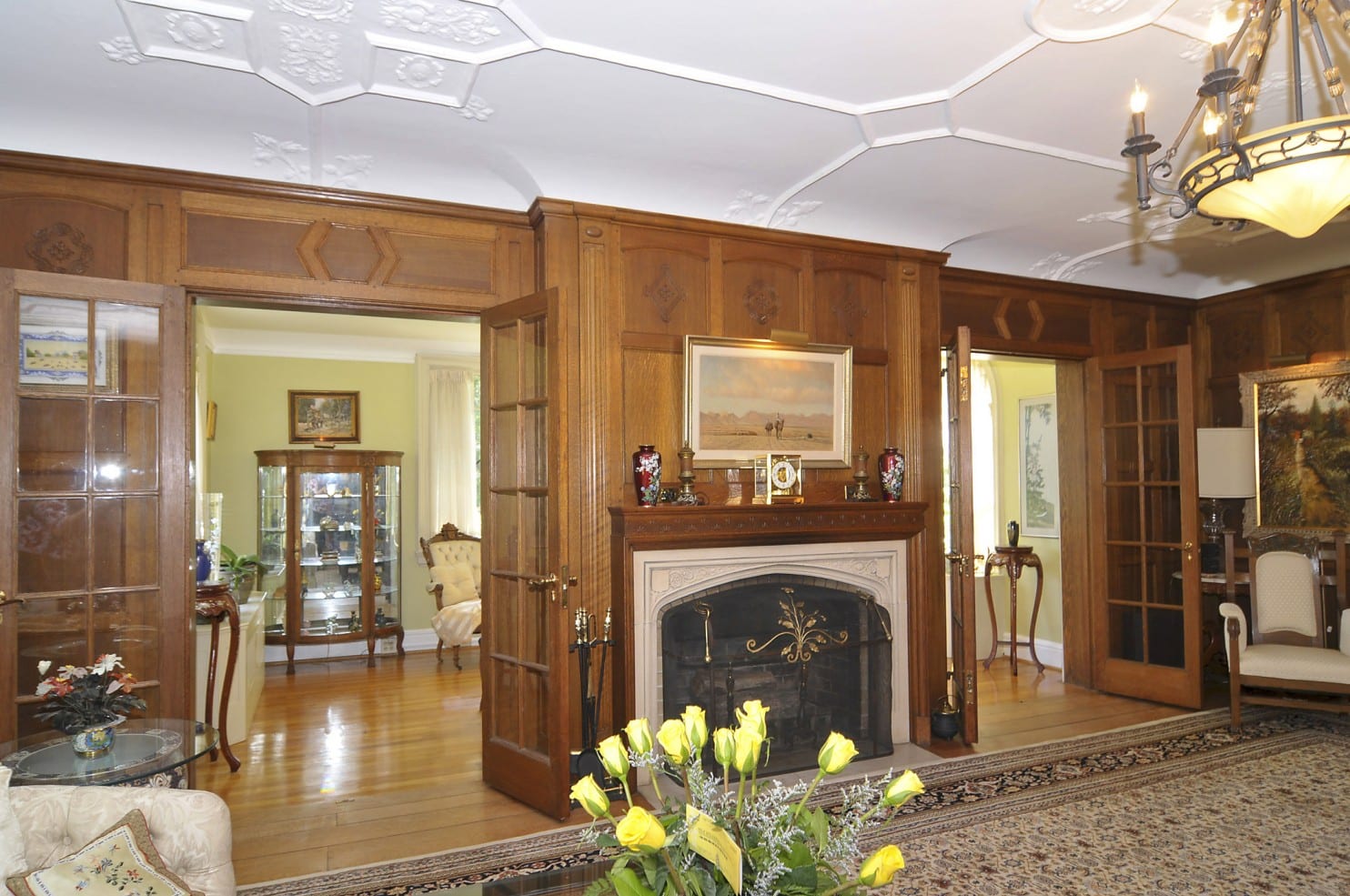 (Photo by HomeVisit) The living room has a cast stone fireplace with a chestnut mantel.