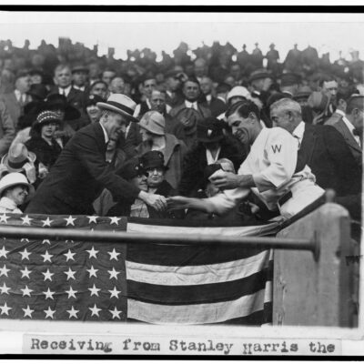 Manager Stanley Harris, in the grandstand, presents President Coolidge with the baseball used to open the 1924 World Series (October 4th, 1924)