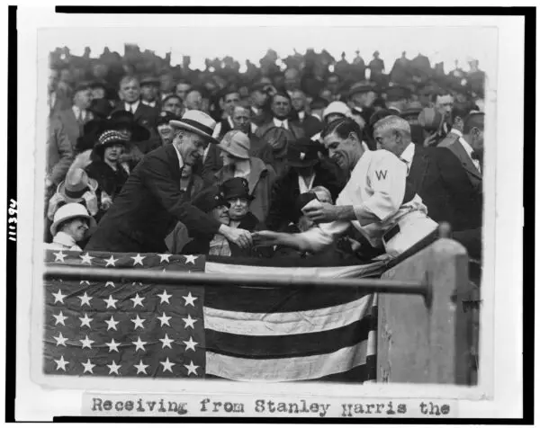 Manager Stanley Harris, in the grandstand, presents President Coolidge with the baseball used to open the 1924 World Series (October 4th, 1924)