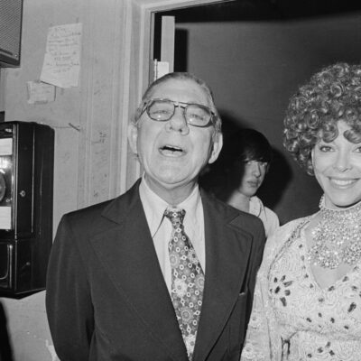 Congressman Wilbur Mills and exotic dancer Fanne Foxe speak with reporters outside Foxe’s dressing room in 1974. (Bettmann Archive via Getty Images)
