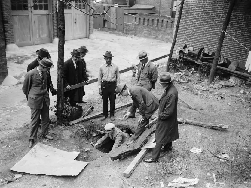 A 1924 photo shows workmen in Washington D.C. gathered around a large hole in the ground behind a house, revealing a set of concrete tunnels underneath. This accidental discovery of elaborate secret tunnels at Harrison Dyar's old home at 1512 21st St. NW kicked off a mystery that fascinated the city.