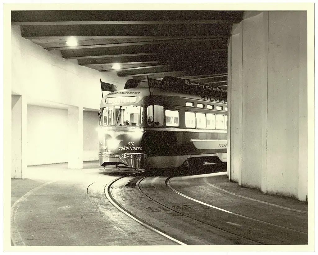 Black and white photograph from 1961 showing the Silver Sightseer, a refurbished, air-conditioned D.C. Transit trolley, in a tunnel under the U.S. Bureau of Engraving and Printing building in Washington, D.C.