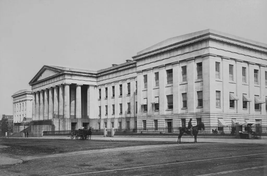Black and white photograph from the A. D. White Architectural Photographs collection, showing the U.S. Patent Office in Washington D.C., designed by architect William P. Elliot, with the building dating back to 1836-1867. The photo dates approximately between 1867 and 1877, showcasing the historic structure located in the United States' capital.