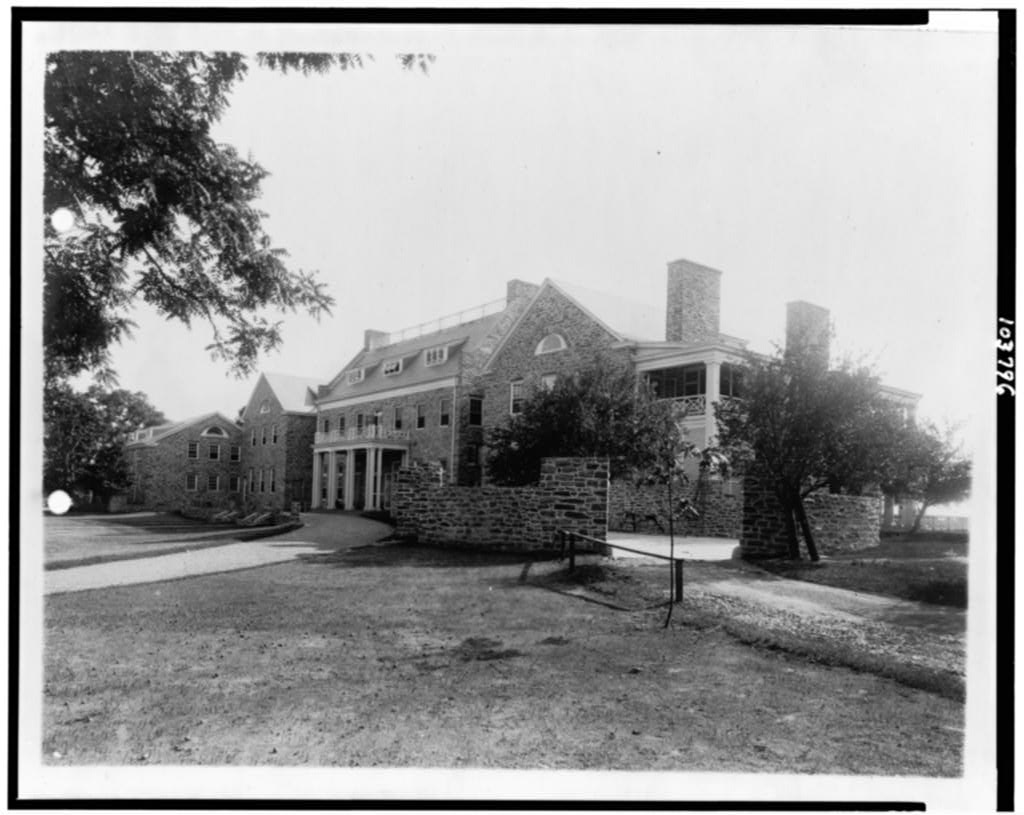 Stone clubhouse of the Chevy Chase Club with chimneys and stone walls in the foreground