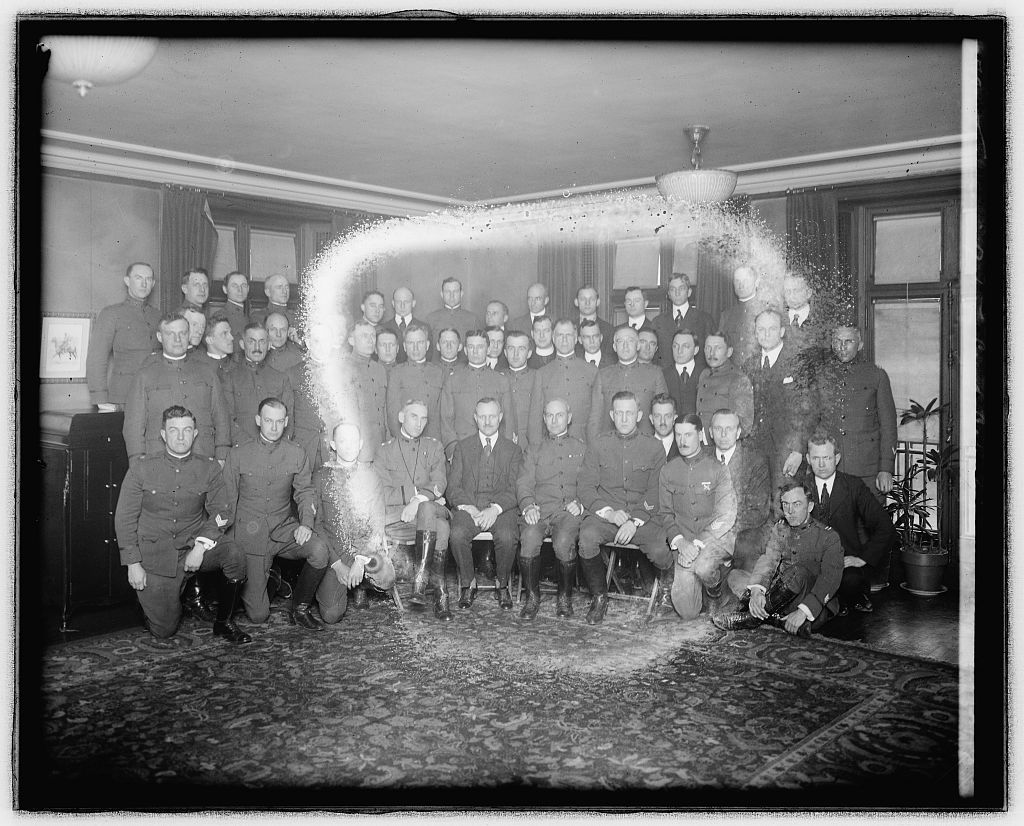 Group photograph of about thirty World War I officers and civilians of the Commission on Training Camp Activities posed inside a paneled room at the Army and Navy Club, 1918