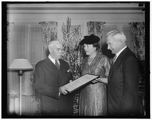 Brigadier General David L. Brainard, last survivor of the 1881 Greely Arctic Expedition, receiving a framed scroll from two presenters at the Army and Navy Club on his 80th birthday in December 1936