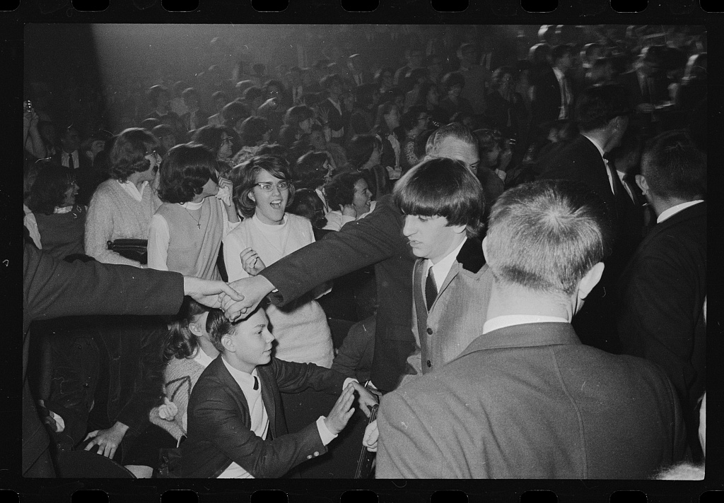 Ringo Starr surrounded by fans and security at Washington Coliseum on February 11, 1964.
