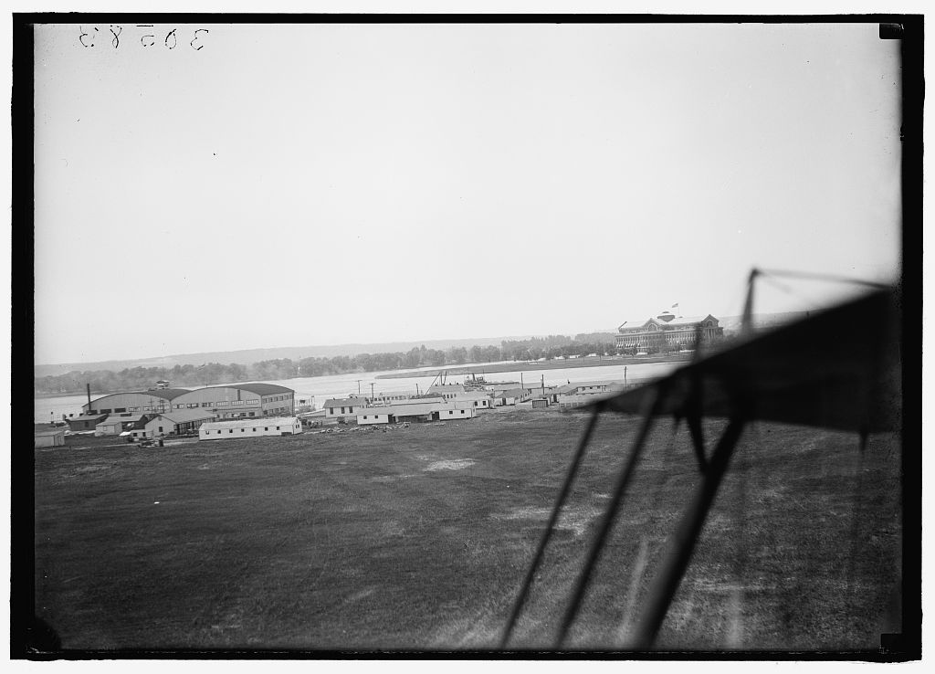 Bolling Field with the Anacostia River and Naval Air Station across, 1919, viewed from beside a parked biplane