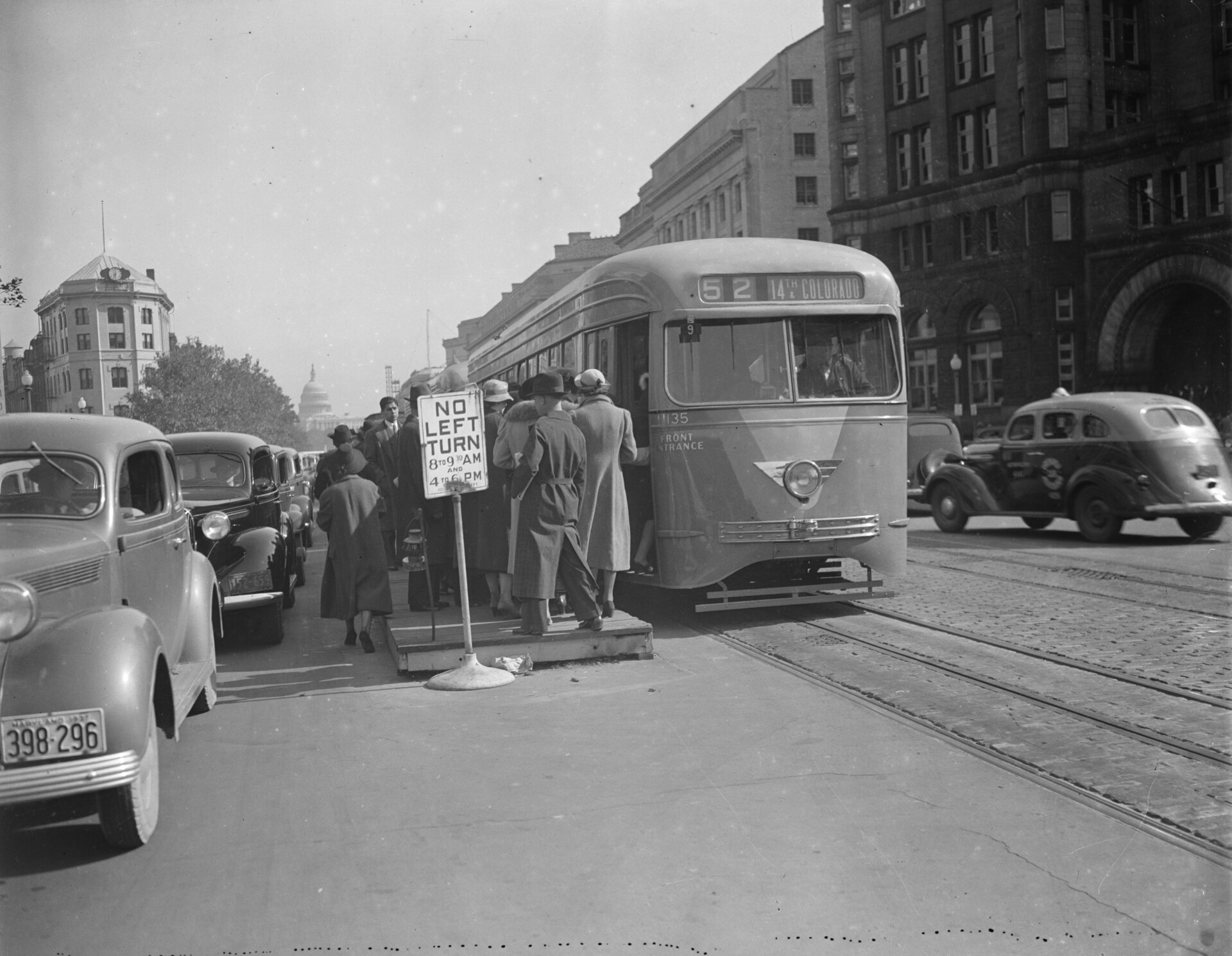 A Capital Transit streetcar boarding passengers on a downtown Washington street in 1937 with the U.S. Capitol dome in the background