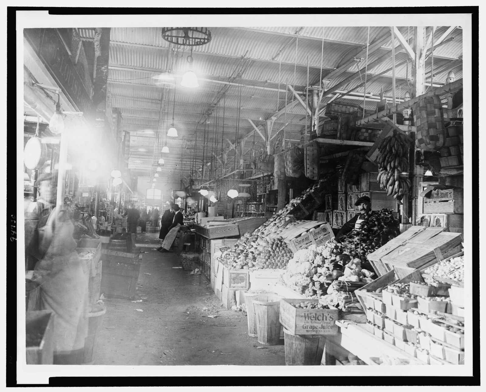 Center Market in Washington D.C. around 1909, with the 7th Street wing and its corner tower, awnings over the curb stalls, and pedestrians on the sidewalk.