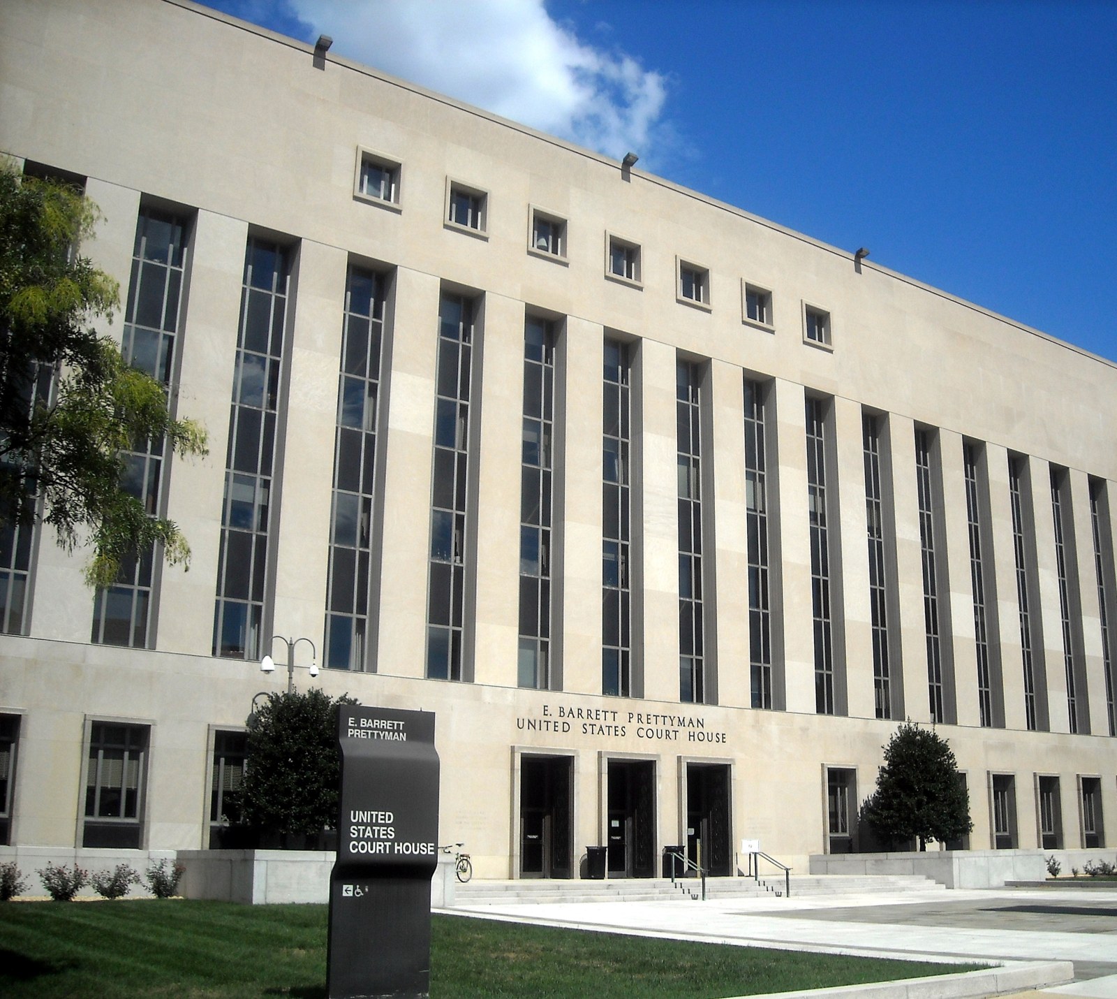 Stone facade of the E. Barrett Prettyman Federal Courthouse in Washington DC photographed during the day.