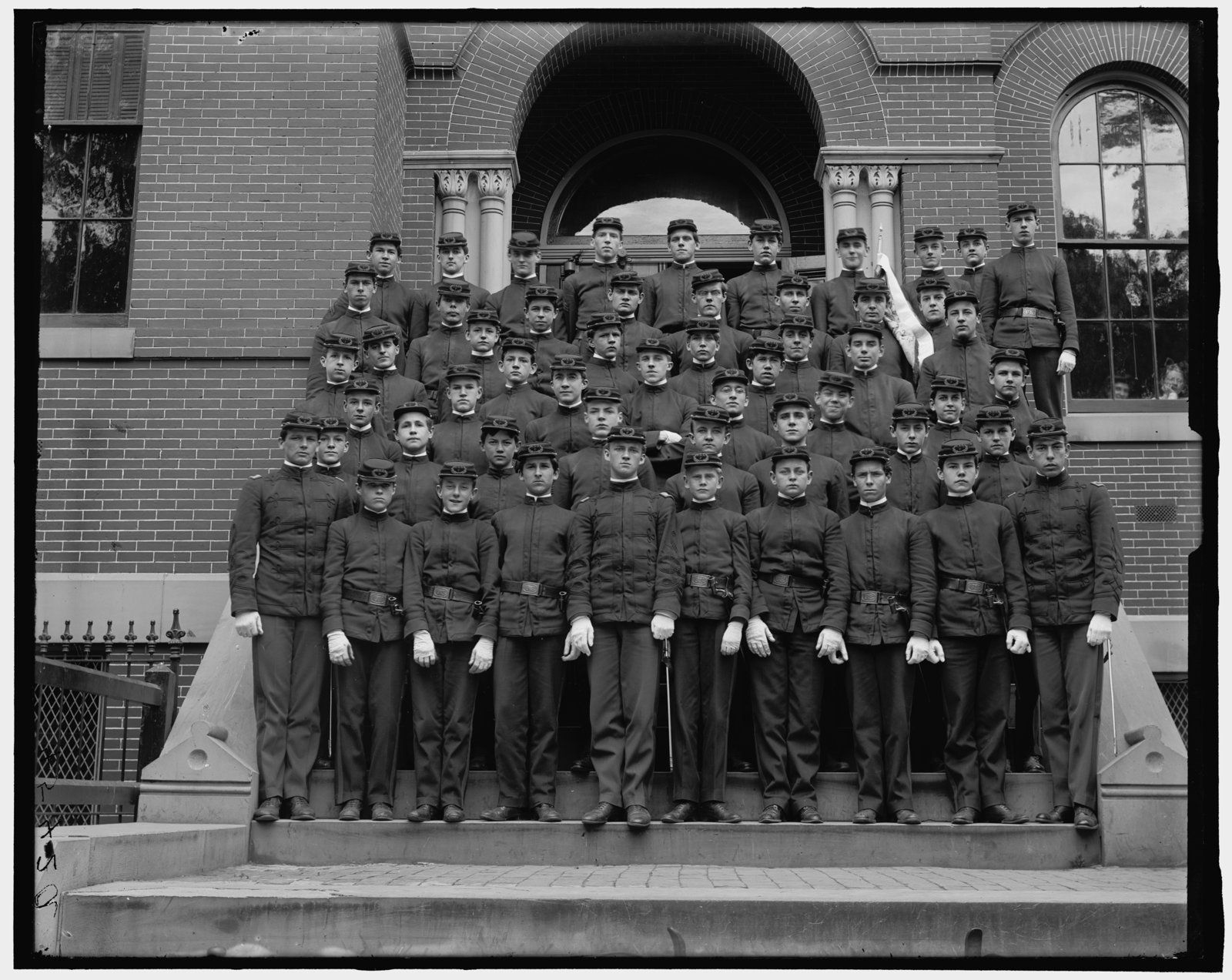 Eastern High School cadet corps in uniform on the school steps in the early 1900s
