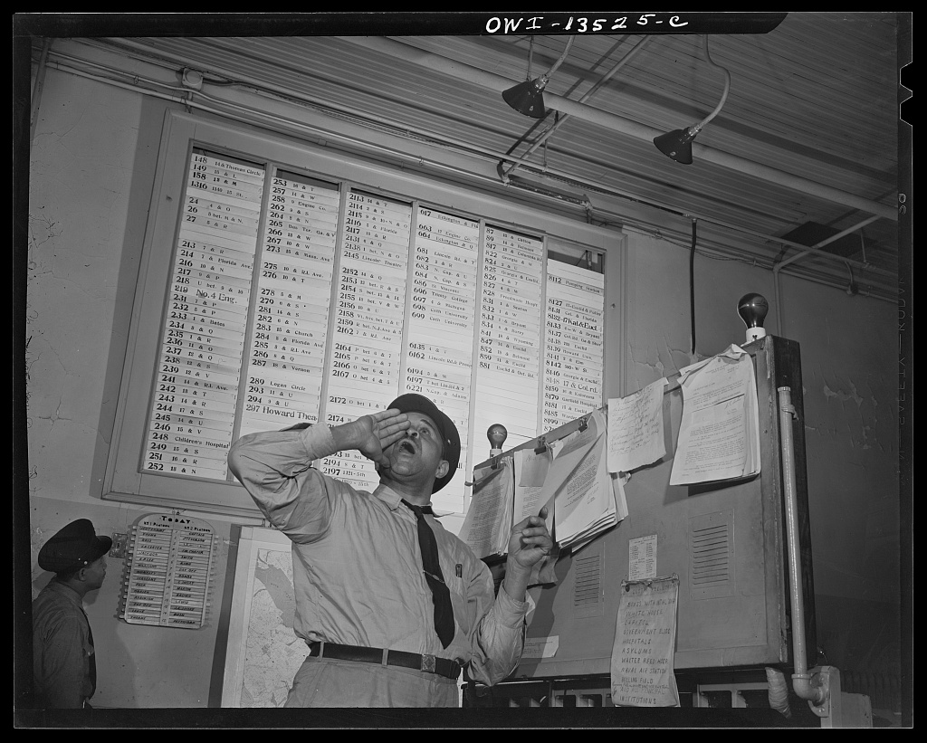 A firefighter at the alarm desk inside Engine Company No. 4 calling out the location of a fire