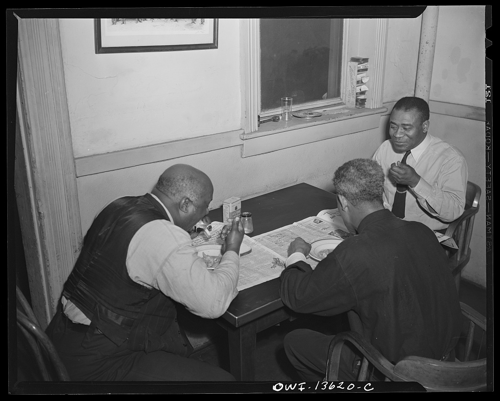 A firefighter at Engine Company No. 4 eating a midday meal in the firehouse kitchen, 1943