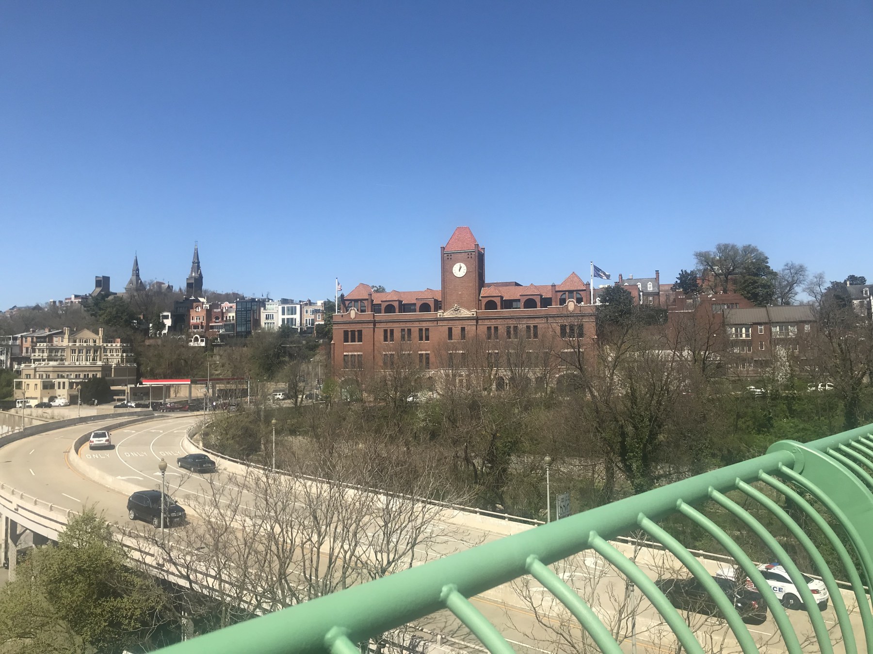 The Romanesque clock tower of the Georgetown Car Barn rising above the District side of the Key Bridge