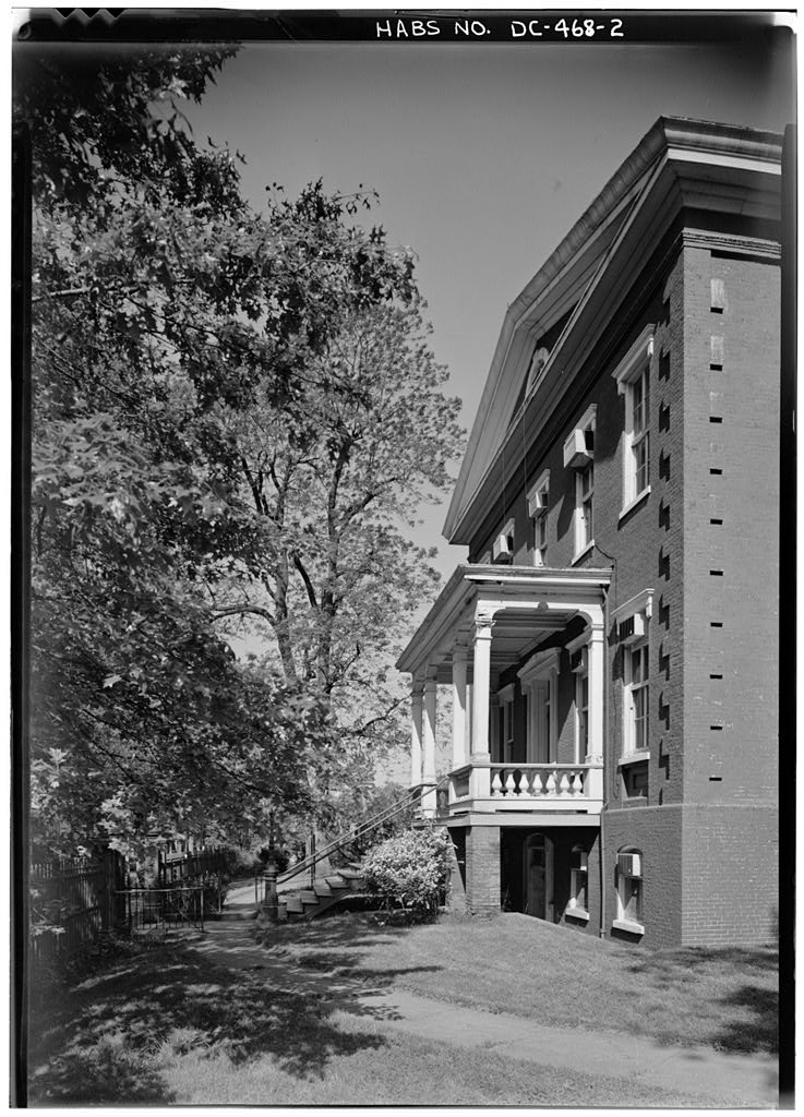 Oblique black and white view of the Old Naval Hospital showing its deep eaves, bracketed cornice, and side elevation