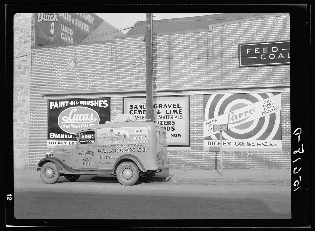 A Rosslyn, Virginia street in 1937 with painted advertisements for feed, coal and paint, photographed by John Vachon