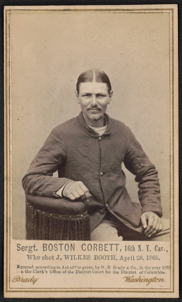 Sergeant Boston Corbett of the 16th New York Cavalry, photographed by Brady in Washington, 1865, in dress uniform with a hat resting on his lap.