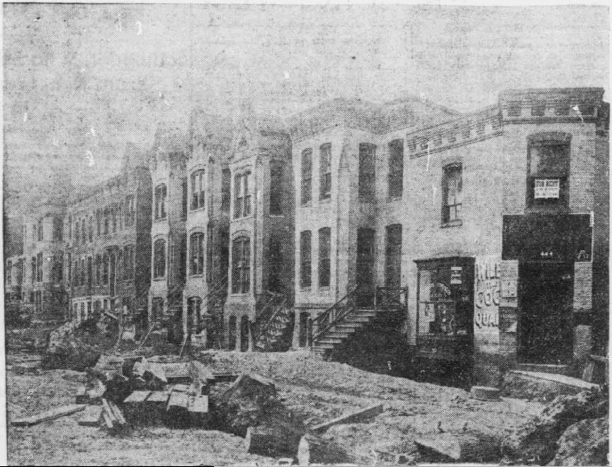 Black and white 1904 photograph of wood-frame row houses on First Street Northeast in the Swampoodle neighborhood of Washington, marked for demolition.