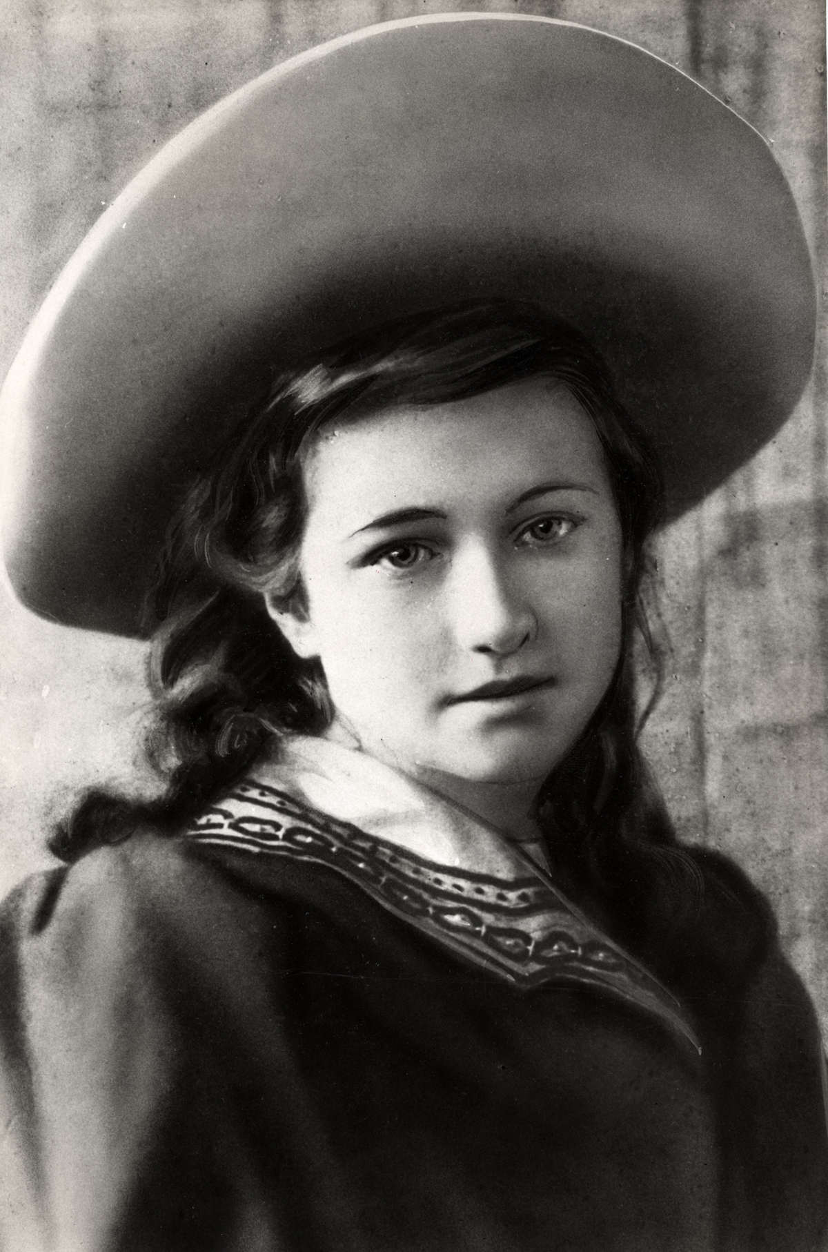 Wallis as a young girl with long hair and a hat