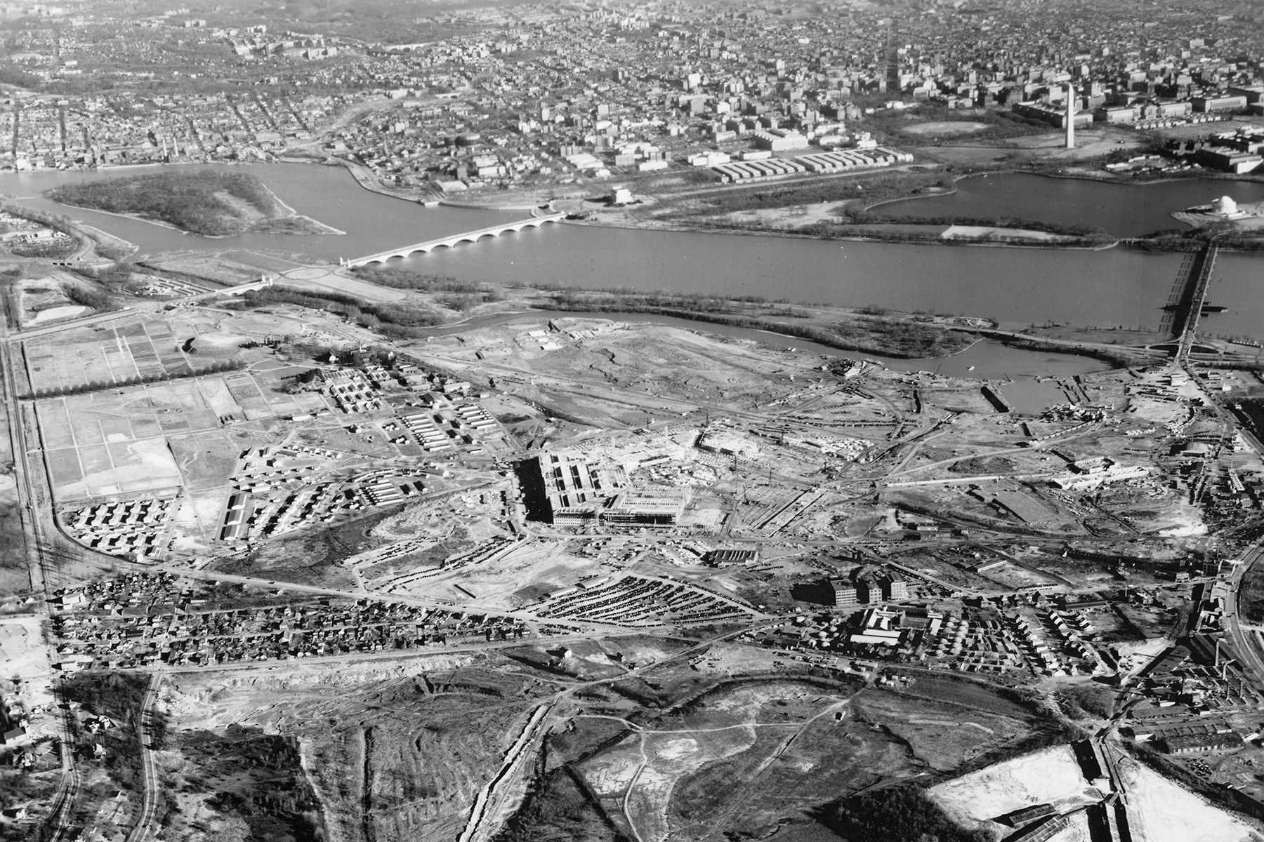 Pentagon construction, aerial view from the southwest in late February 1942, with two sides nearly complete and the Washington Monument visible across the Potomac