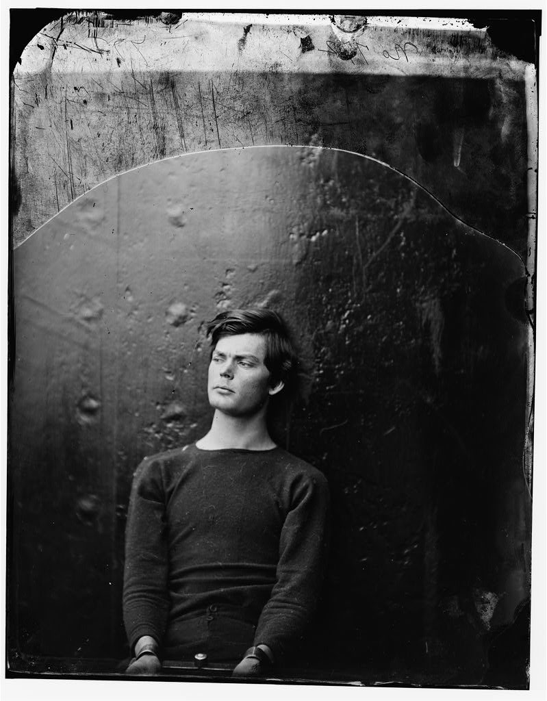 Lewis Powell seated in a sweater on the USS Saugus, manacled, photographed by Alexander Gardner after his arrest in April 1865