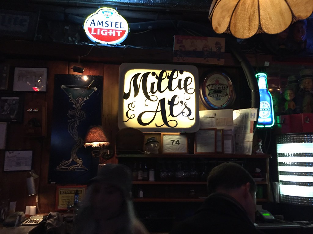 The illuminated Millie and Al's back-bar sign among the beer neons, April 6, 2016. Photo by Joe Flood via Flickr, used u