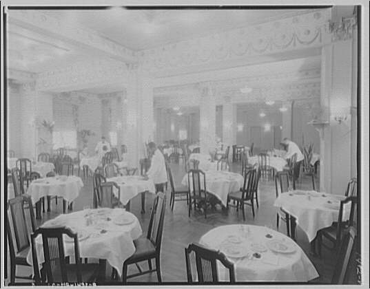 Waiters set the public dining room at Meridian Mansions