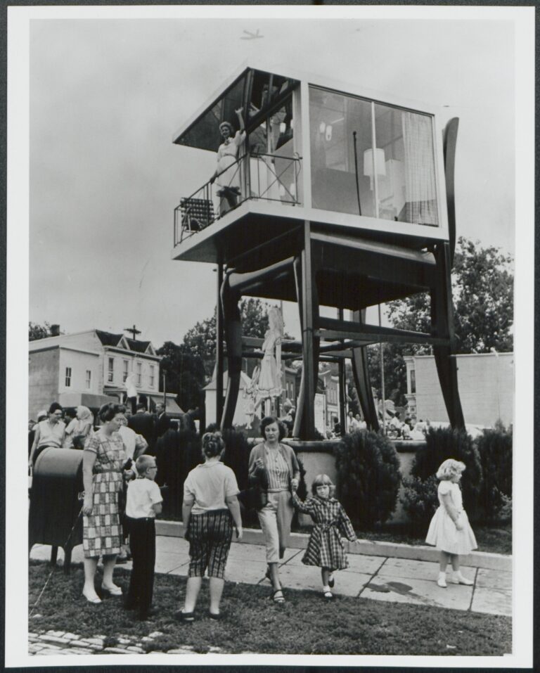 Lynn Arnold waves from the glass house atop the Big Chair in Anacostia, 1960