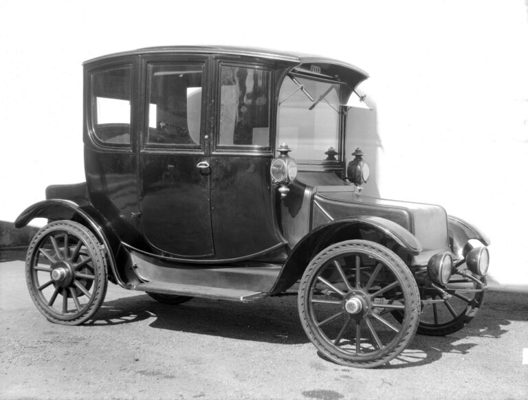 A Rauch and Lang electric automobile with an enclosed passenger compartment and spoked wheels.